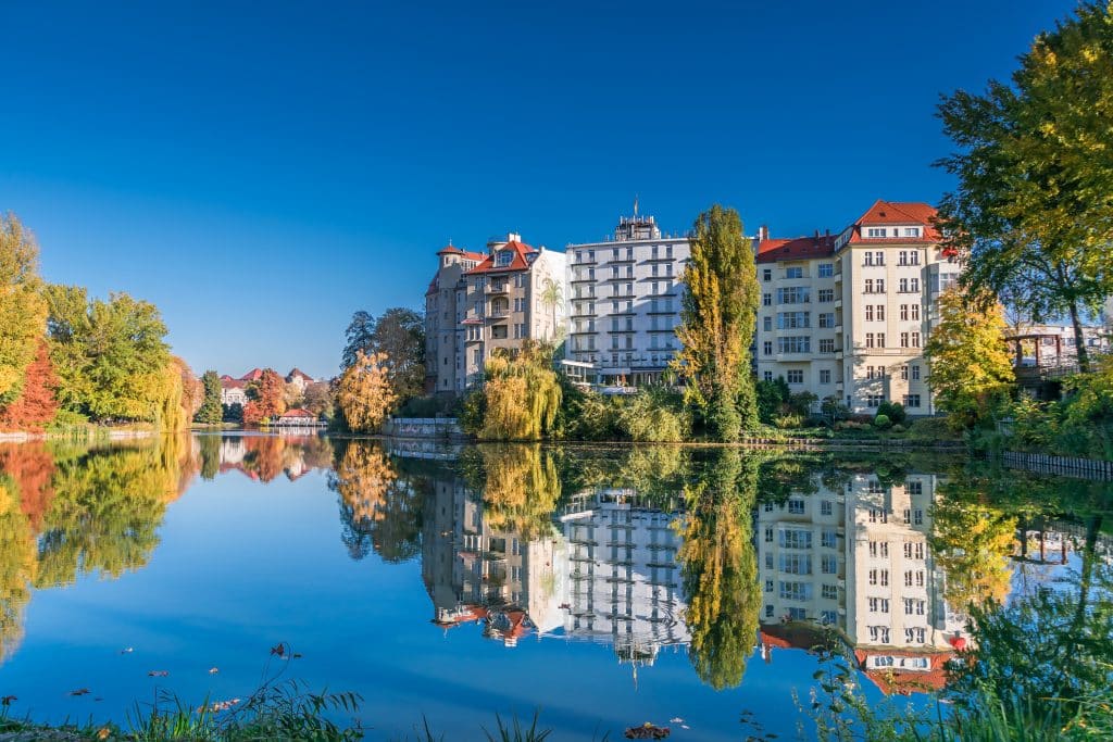 Der Park am Ufer des Lietzersees mit Gebäuden, die sich im Wasser spiegeln, im Berliner Stadtteil  Charlottenburg