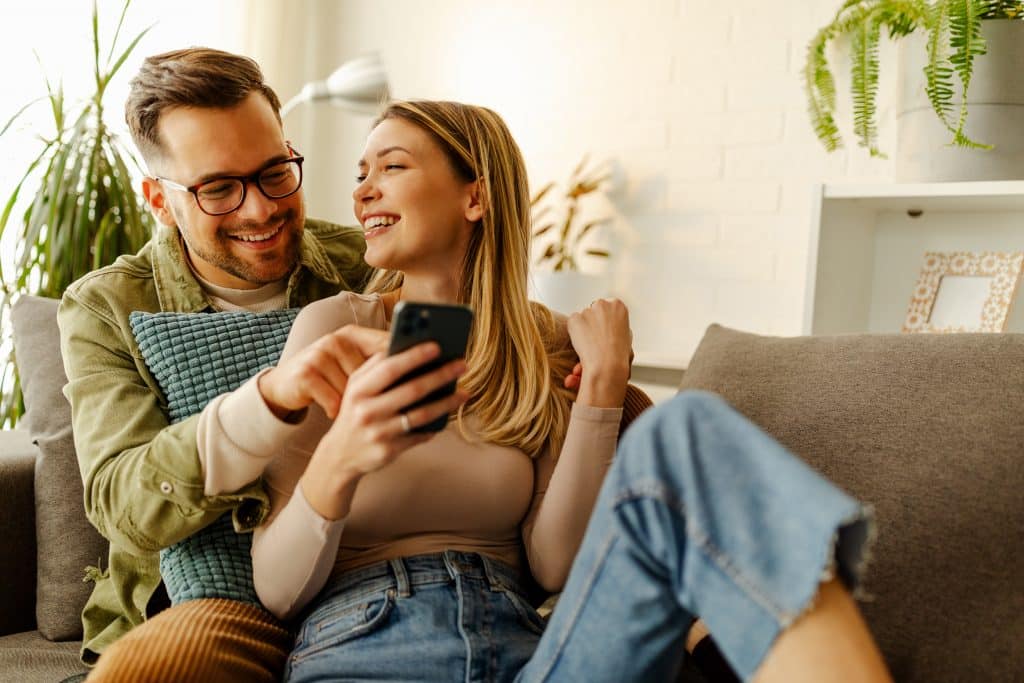 Overjoyed couple relax on the couch